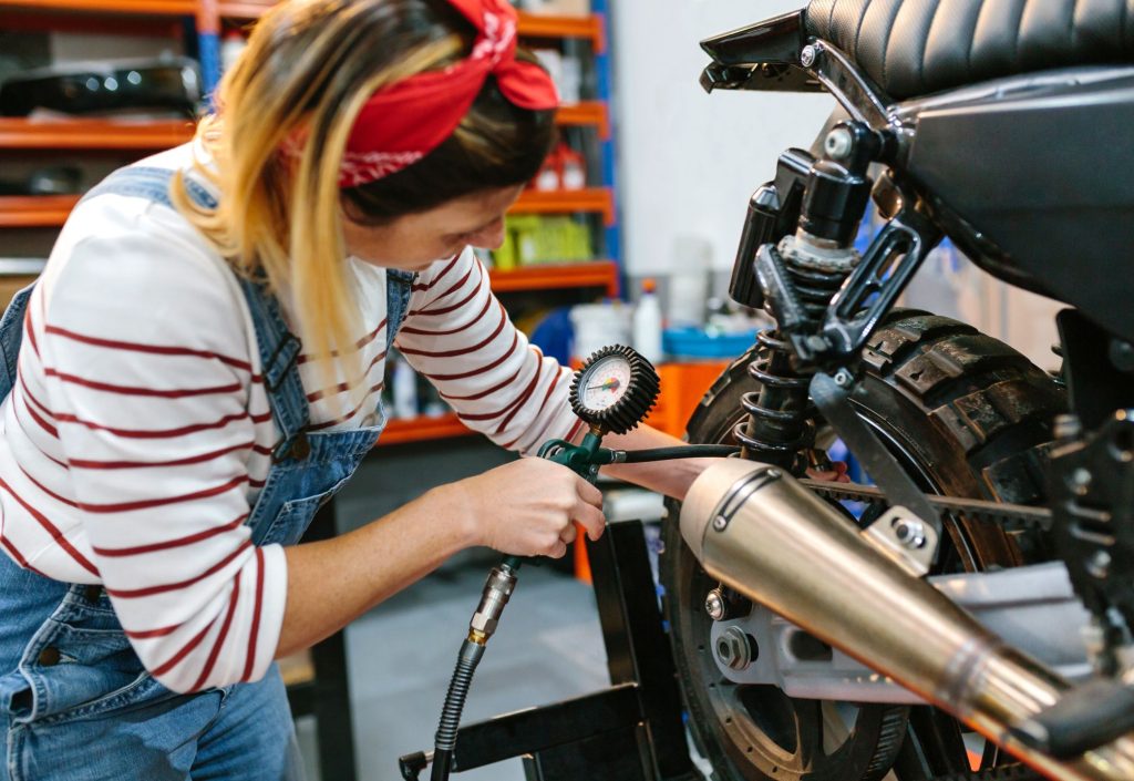 Una dueña de una motocicleta calibrando la llanta de su motocicleta 