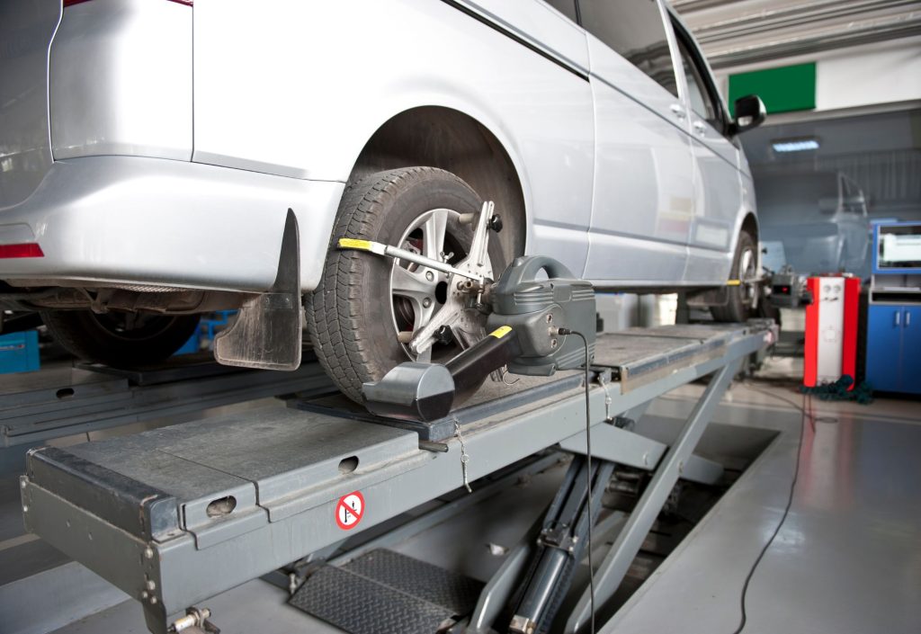 Una camioneta en un taller mecánico recibiendo una alineación y balanceo 