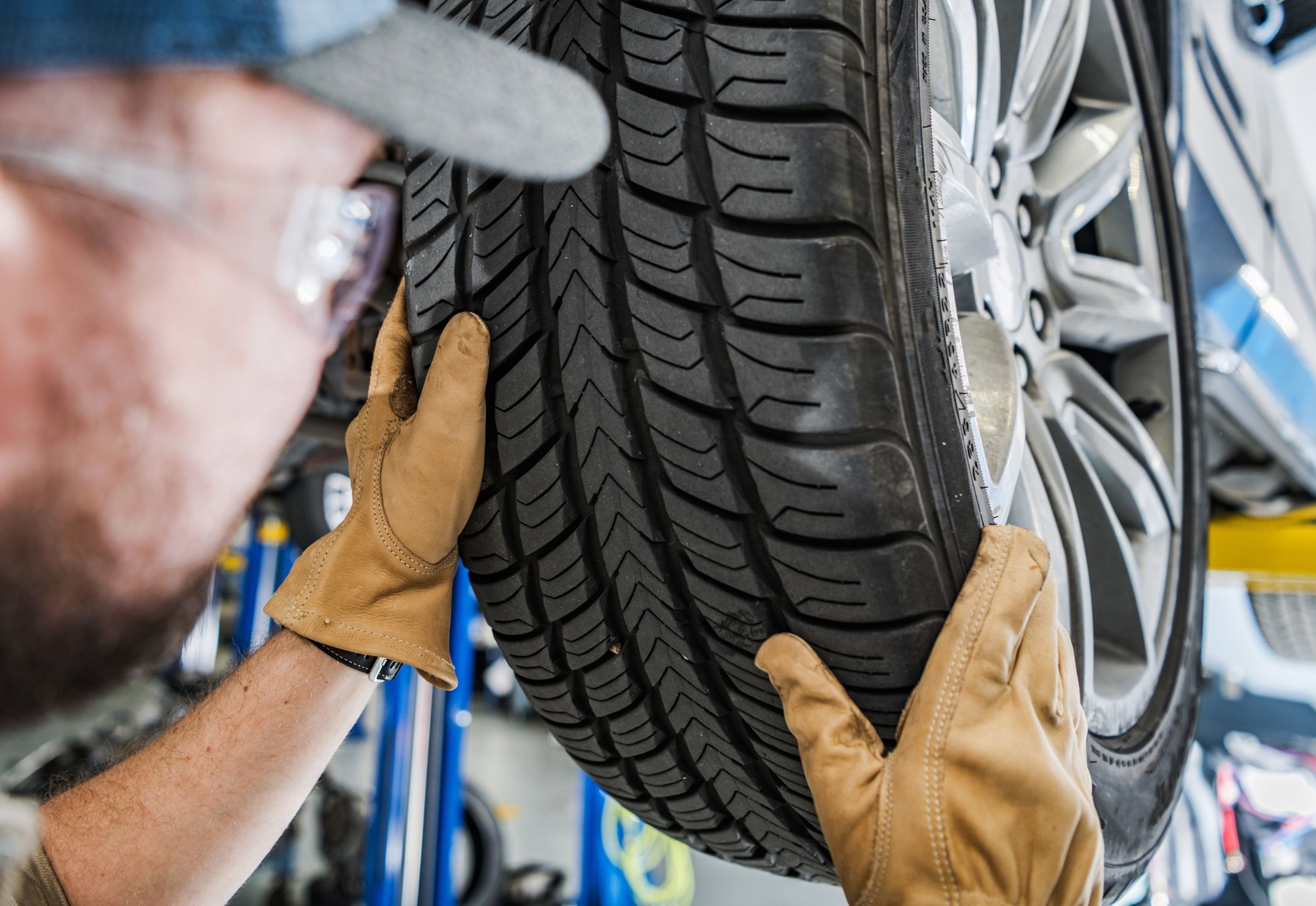 Mecánico preguntándose ¿Cuándo cambiar las llantas?, cambiando una llanta de un coche